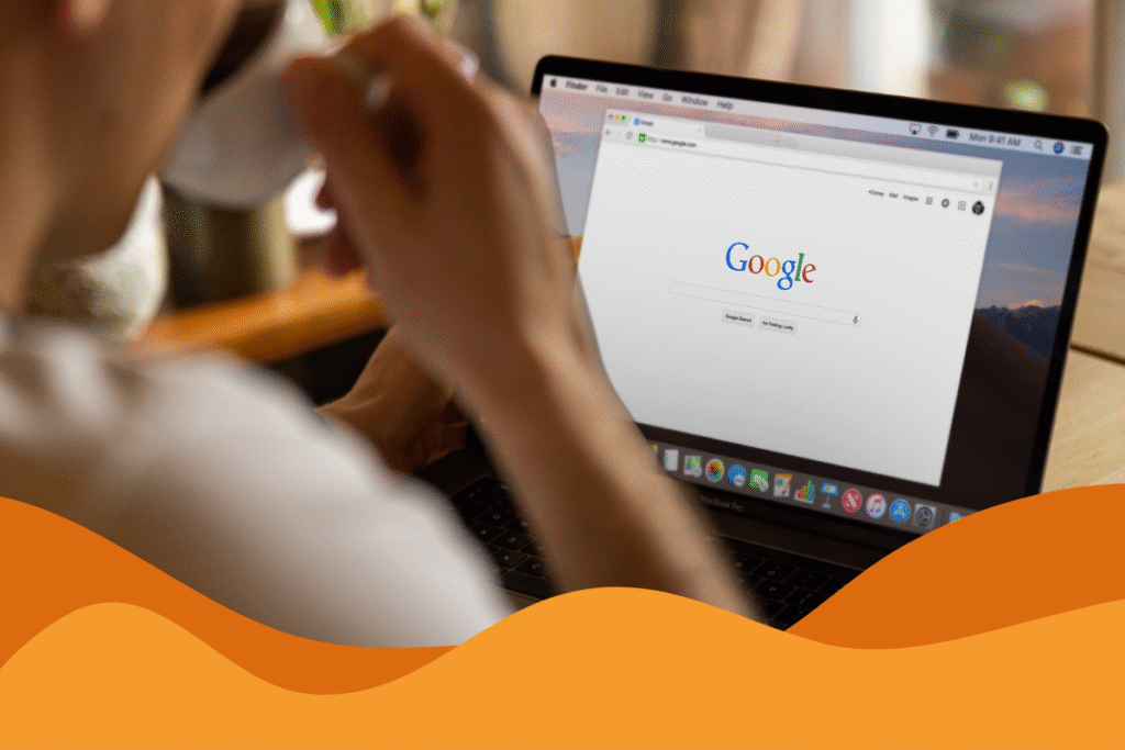 image of a person drinking coffee in front of a black laptop with google search bar on the screen, in an article about googles mcc scam on the rise