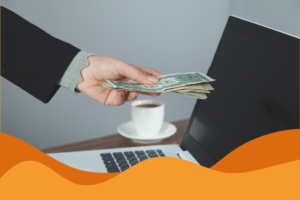 Image of a hand giving cash to its MacBook in an article explaining the costs of managed IT support for businesses in and around Sheffield by Daffodil IT in South Yorkshire.