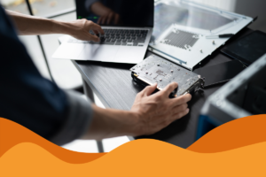 image of an it support technician fixing a MacBook on a grey desk in an article answering what is managed it support and how can SMEs in Sheffield benefit from an MSP by Daffodil IT in Sheffield, South Yorkshire serving customers across Sheffield, Chesterfield, and further.