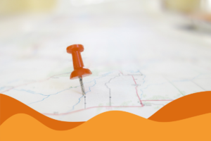 Red pushpin marking a spot on a map with orange wave graphic at bottom.